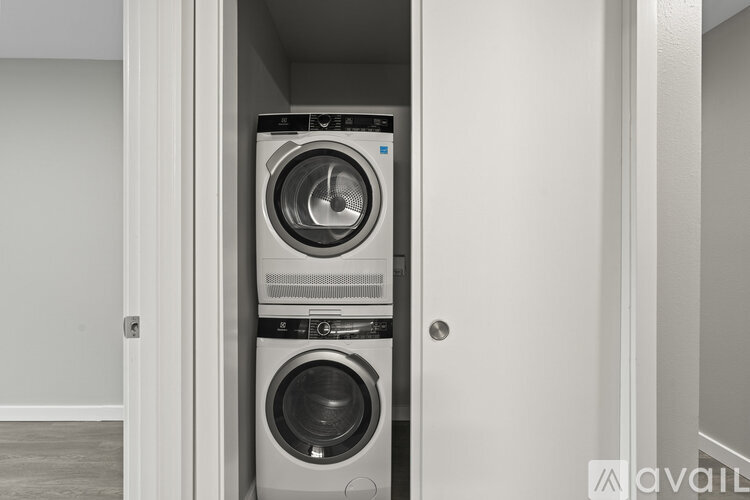 A stacked washer and dryer in a small space.