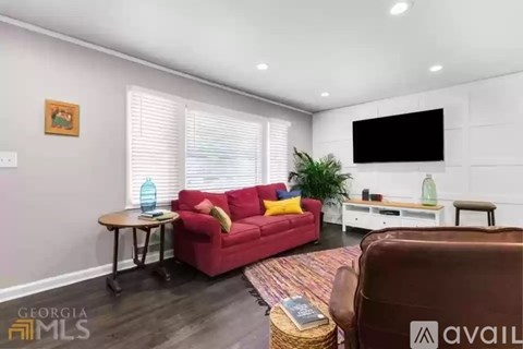 A living room with a red couch and a brown chair.