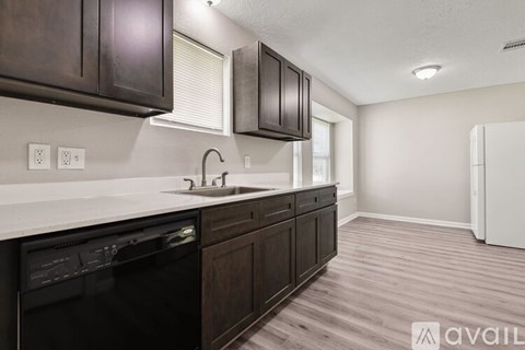 A kitchen with dark wood cabinets and a white countertop.