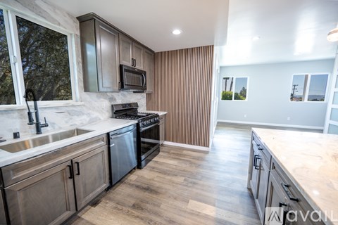 A kitchen with wooden cabinets and a marble countertop.