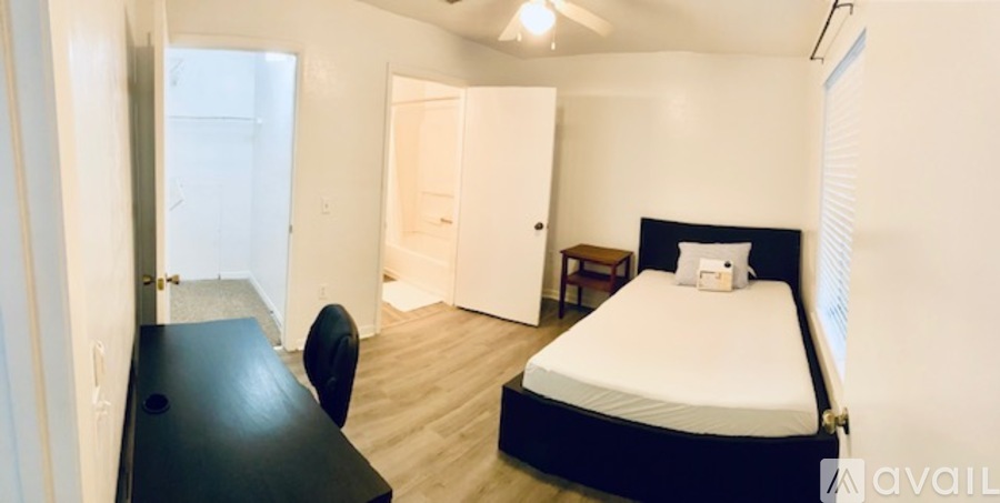 A bedroom with a bed, desk, and chair.