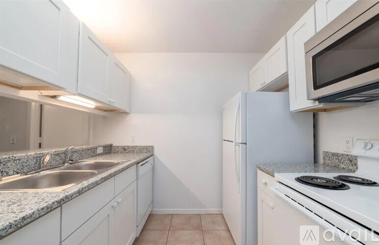 A kitchen with white cabinets and granite countertops.