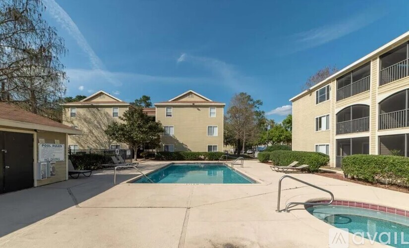 A swimming pool in a sunny day surrounded by buildings.