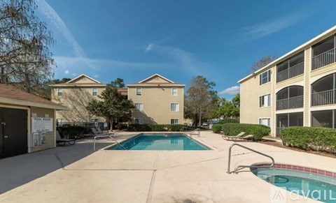 A swimming pool in a sunny day surrounded by buildings.