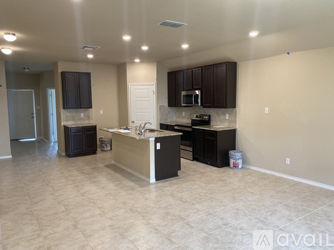 A kitchen with a white countertop and black cabinets.