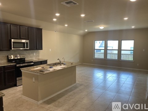 A kitchen with a granite countertop and a microwave above it.