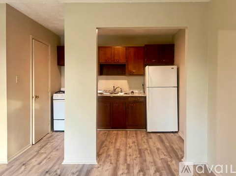 A kitchen with wooden cabinets and a white refrigerator.