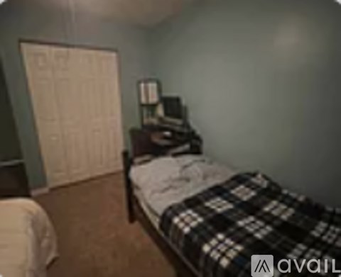 A bedroom with a bed, dresser and closet.