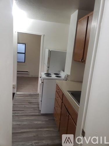 A kitchen with wooden cabinets and a white fridge.