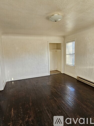 A room with wooden floors and a window.