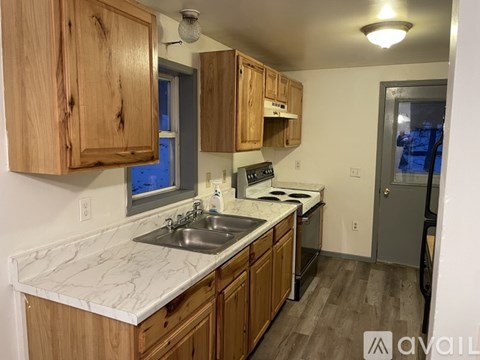 A kitchen with wooden cabinets and a marble countertop.