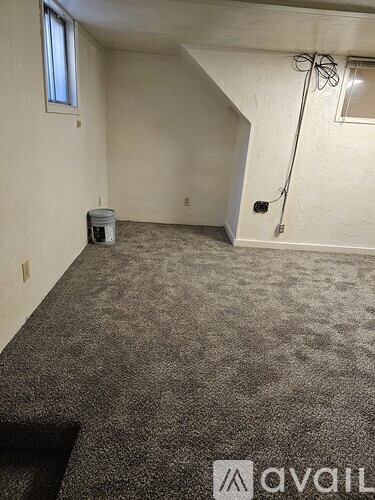 A room with a carpeted floor and a door leading to another room.
