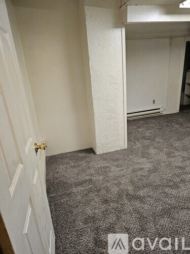 A small, empty room with a carpeted floor and a white wall.
