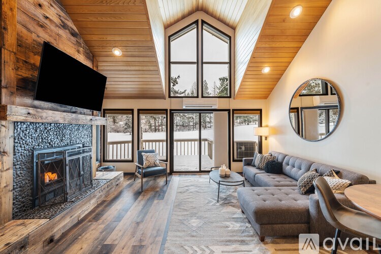 A modern living room with a fireplace and a large window.