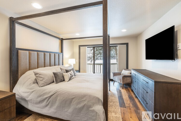 A bedroom with a large bed and a flat screen TV mounted on the wall.