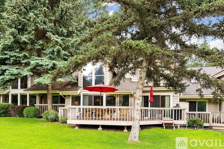 A house with a red umbrella on the deck.