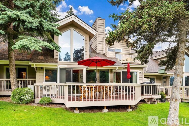 A house with a red umbrella on the deck.
