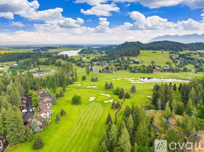 A golf course surrounded by trees and houses.