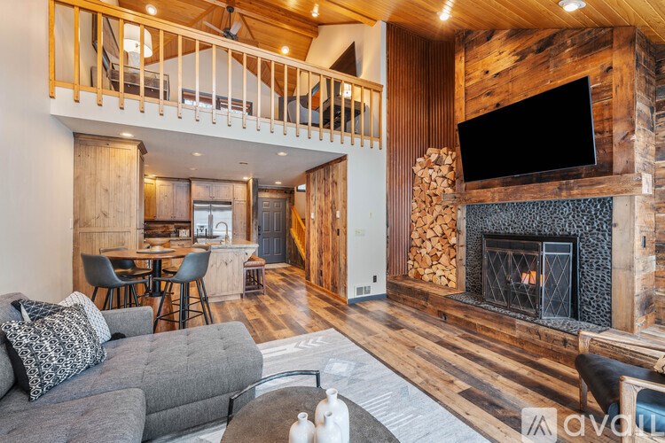 A living room with a grey couch and a fireplace.