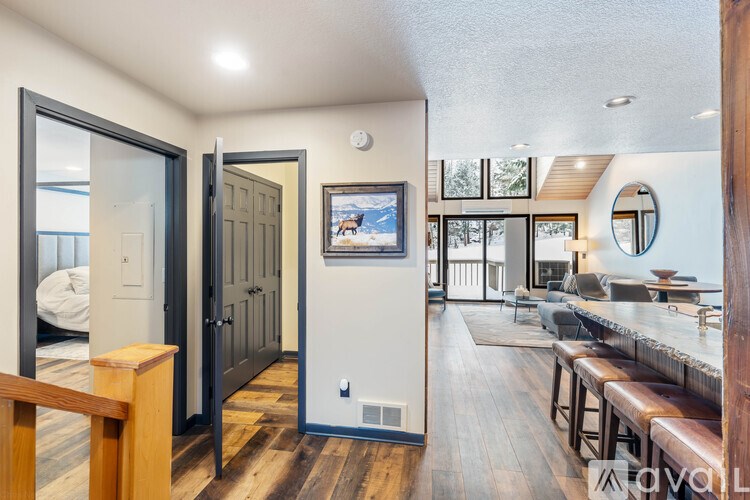 A living room with a couch, a television, and a wooden floor.