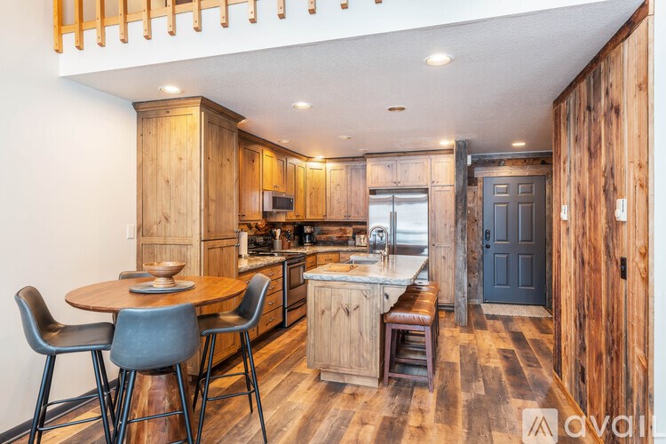A kitchen with wooden cabinets and a table with chairs.