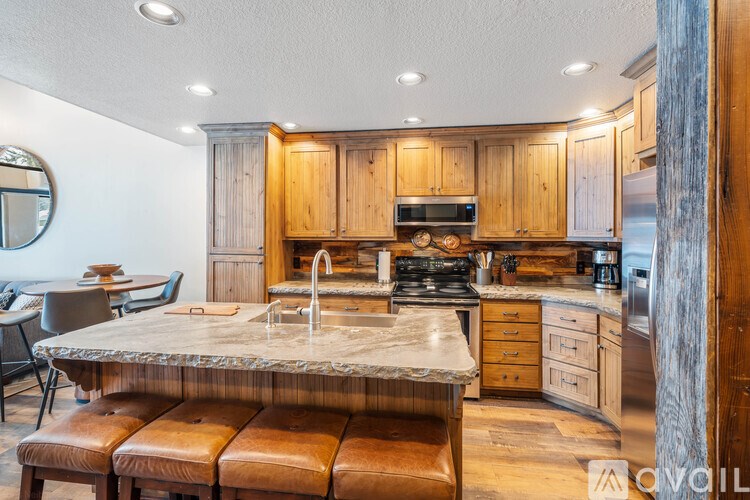 A kitchen with wooden cabinets and a marble countertop.