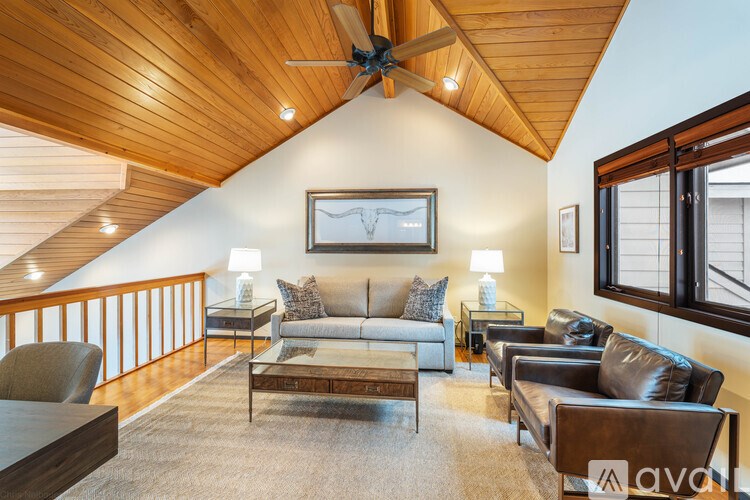 A living room with a wooden ceiling and a couch.