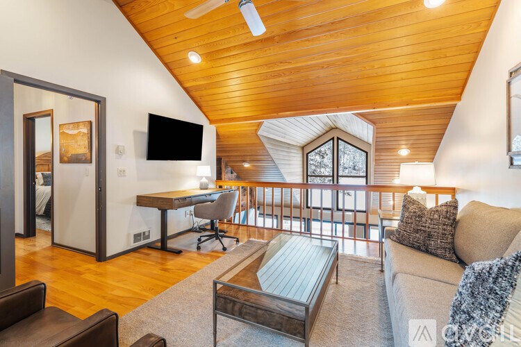 A living room with a couch, a chair, a coffee table, and a television.