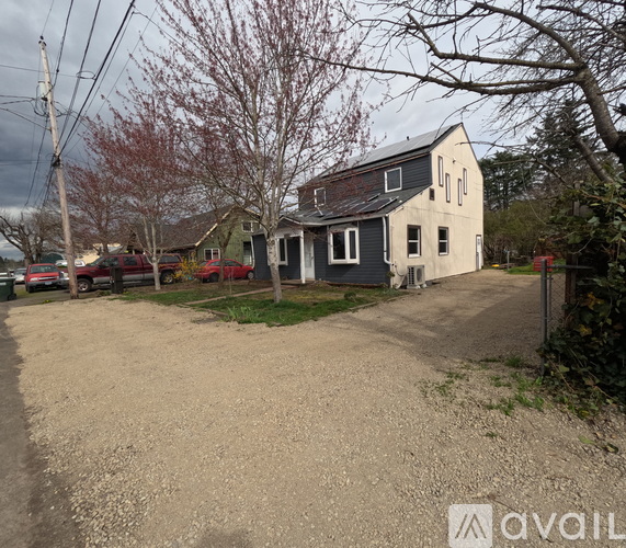 A gravel driveway leads to a house with a garage.