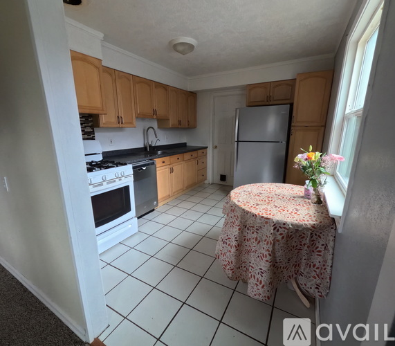 A kitchen with a table and a refrigerator.