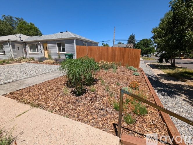 A small garden with a wooden fence and a metal railing.
