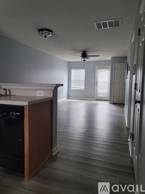 A kitchen with a black oven and wooden cabinets.