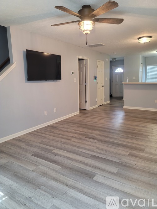A living room with a flat screen TV mounted on the wall.