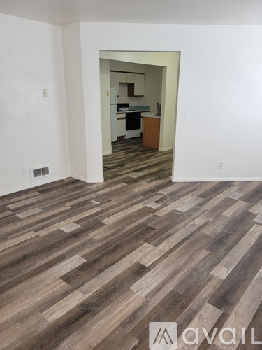 A room with wooden flooring and a mirror on the wall.