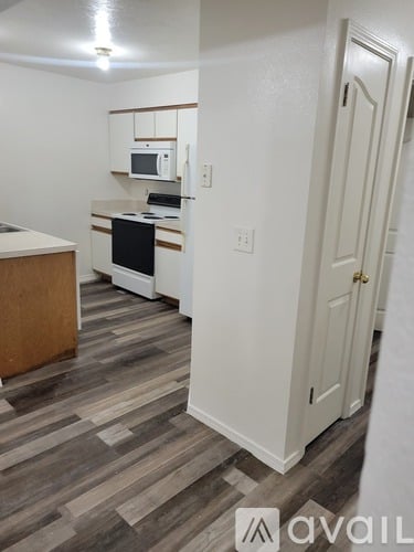 A kitchen with a microwave, oven, and cabinets.