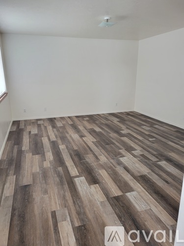 A room with wooden flooring and a ceiling fan.