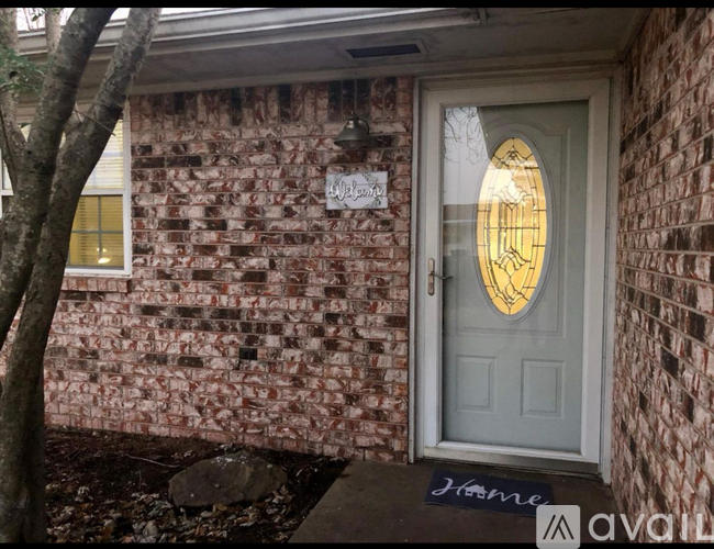 A house with a white door and a brick wall.