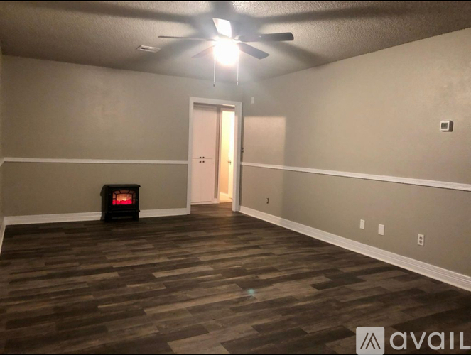 A room with a wood floor and a ceiling fan.