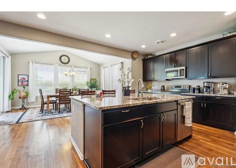 A kitchen with dark wood cabinets and a large island.