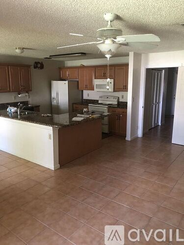 A kitchen with brown cabinets and a white refrigerator.