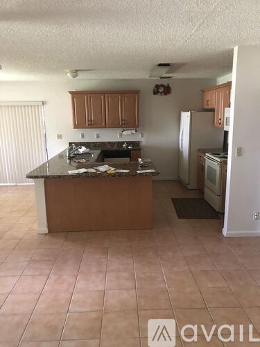 A kitchen with brown cabinets and a black countertop.