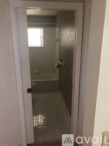 A bathroom with a white door and a tiled floor.