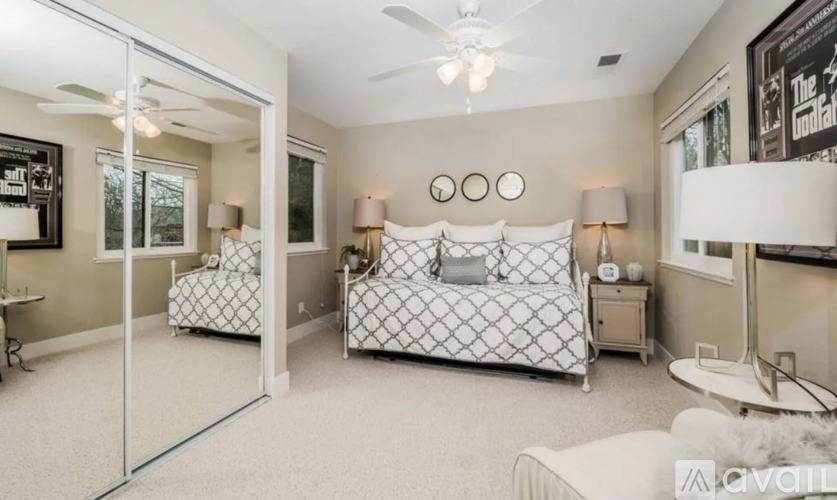 A bedroom with a bed, nightstand, and a ceiling fan.