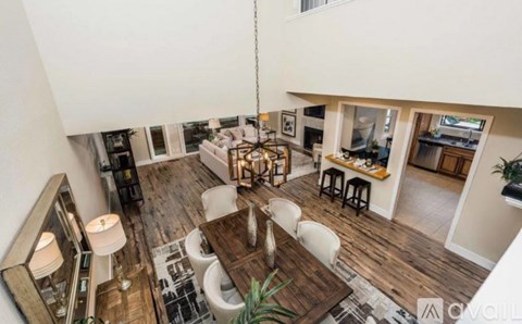 A modern living room with a wooden floor and a large mirror on the wall.