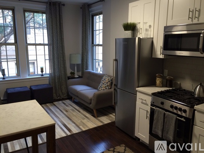 A kitchen with a refrigerator, oven, and microwave.
