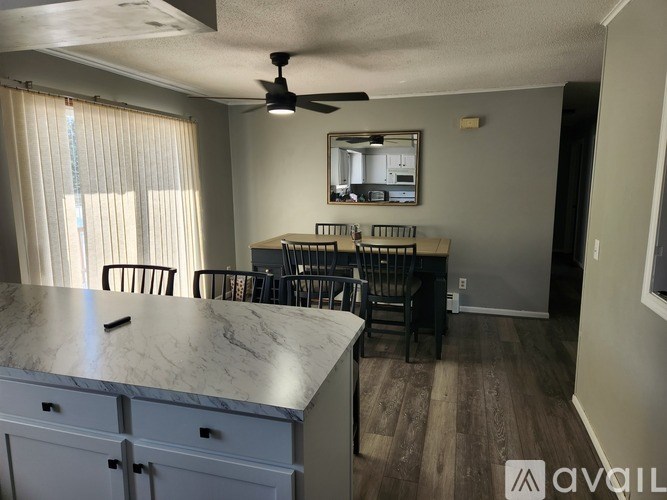 A kitchen with a marble countertop and a ceiling fan.