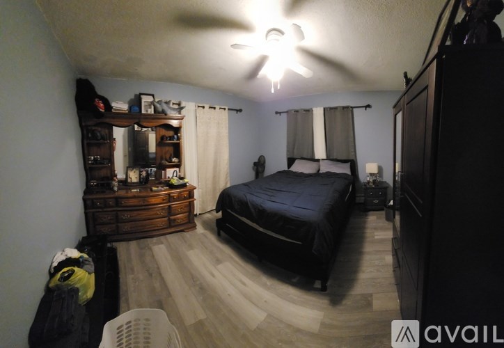 A bedroom with a bed, dresser, and ceiling fan.