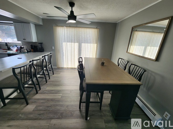A dining room with a wooden table and chairs.