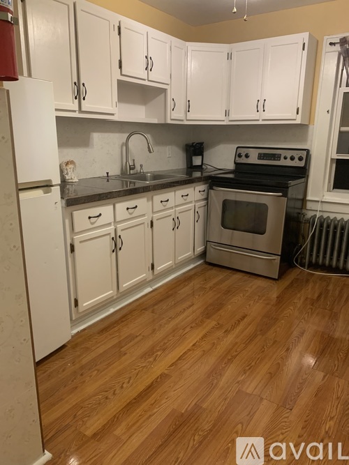 A kitchen with white cabinets and a black stove top oven.