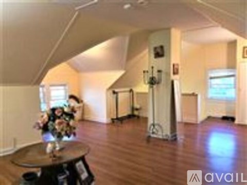 A living room with a wooden floor and a table with flowers on it.